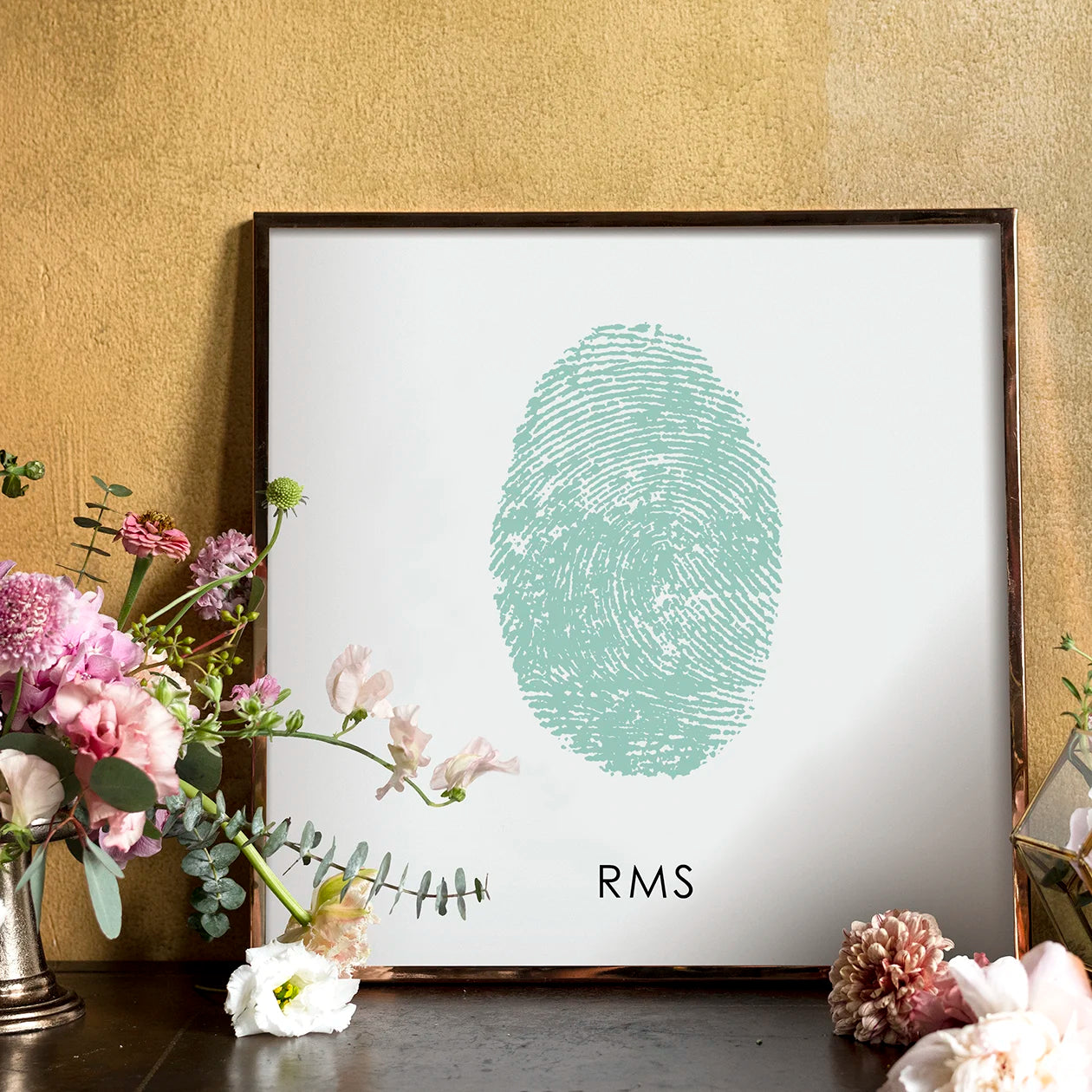 Framed art with overlapping blue and green fingerprints forming a heart, overlayed with