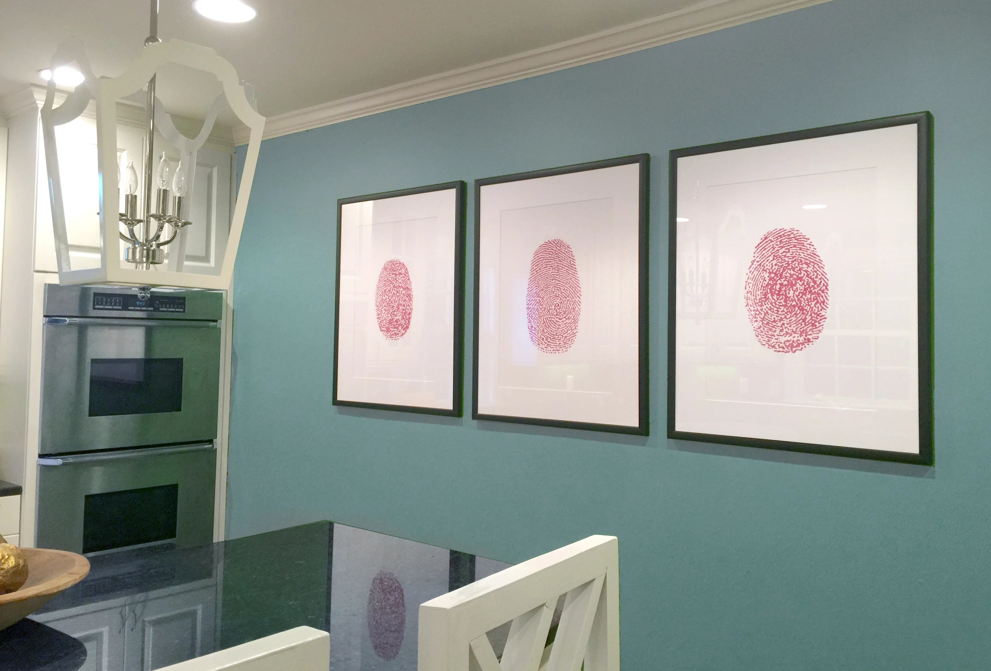 Black-framed print with a white fingerprint heart and sentimental text sits on a wooden shelf, beside a wedding photo, conveying love and intimacy.