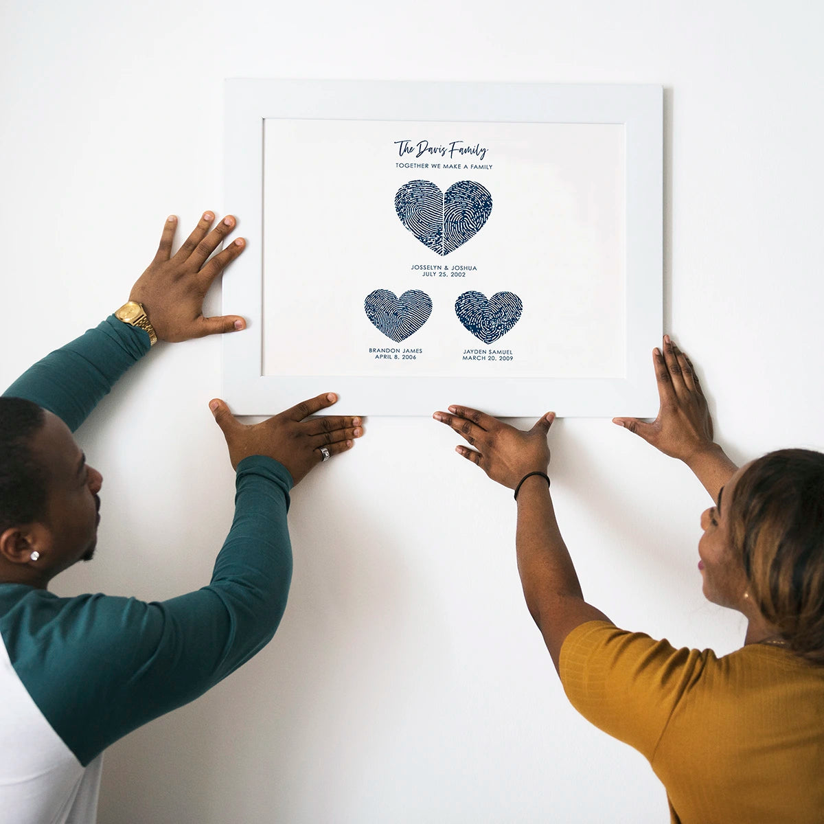 Framed art with overlapping blue and green fingerprints forming a heart, overlayed with