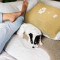 small dog resting on couch with woman next to personalized paw and nose print throw pillow