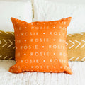 Orange pillow on bed personalized with dog name
