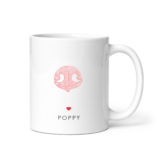 White mug with a pink dog nose illustration above a small red heart and the pet name "POPPY" in black. The design conveys a cute, personal touch.