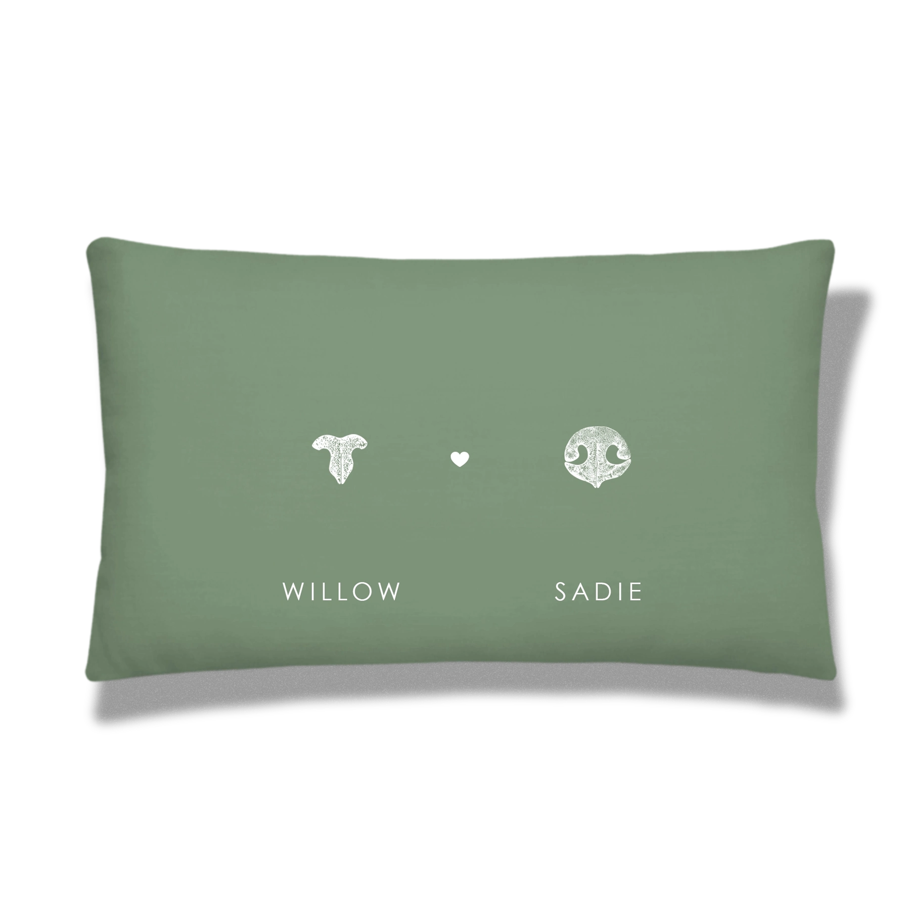 Green pillow with a white cat nose print and white dog nose print, separated by a heart. 
