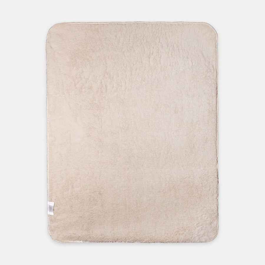A soft, beige, rectangular fleece blanket with rounded corners against a white backdrop. The texture looks plush and cozy, evoking warmth and comfort.