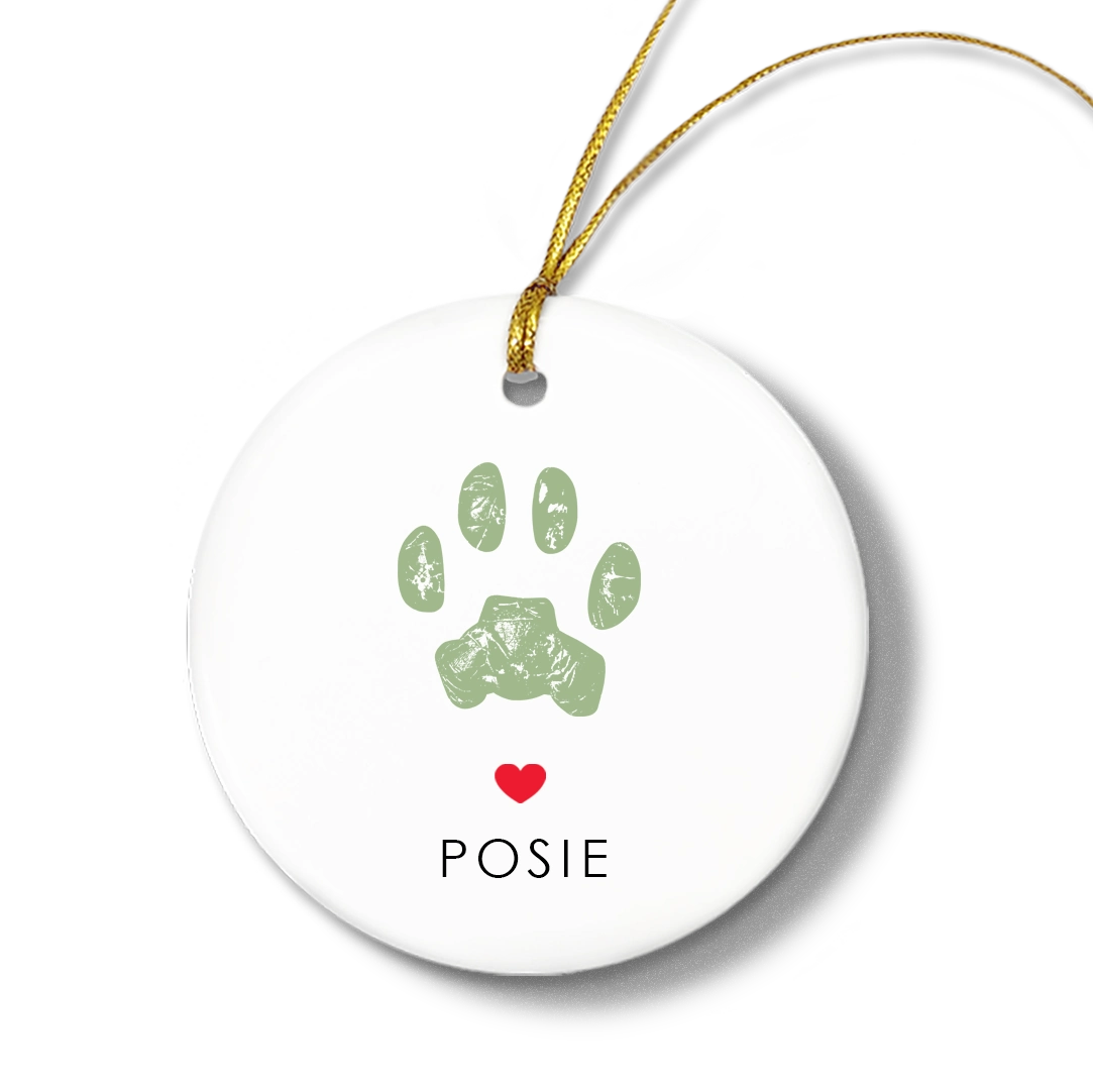 White ceramic ornament with a green cat paw print design, red heart, and 