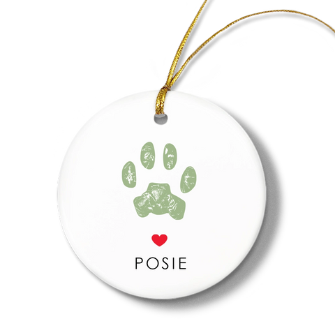 White ceramic ornament with a green cat paw print design, red heart, and 