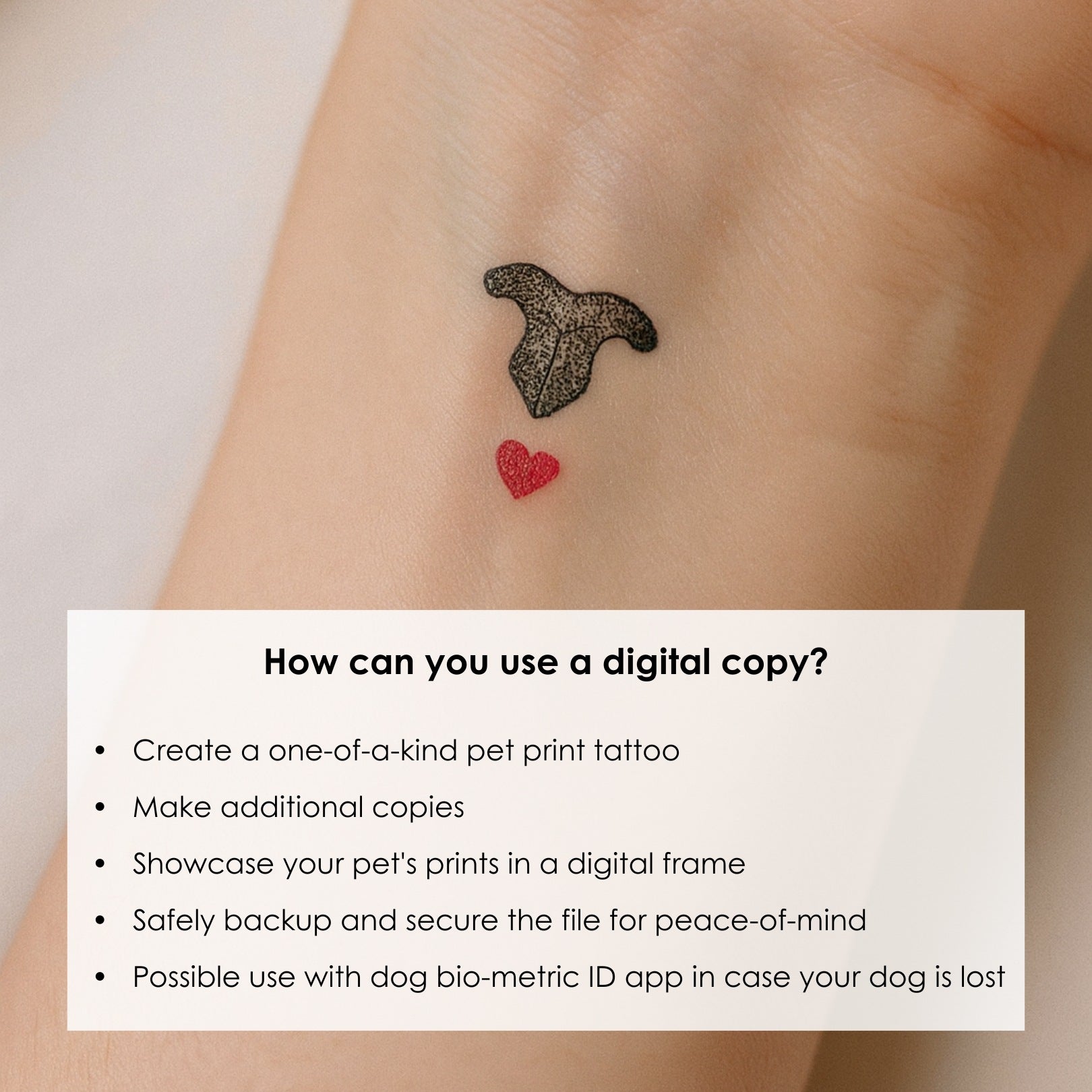A small tattoo on a wrist features a stylized black cat's nose print above a tiny red heart. The design is minimalistic and memorial of pet and love.