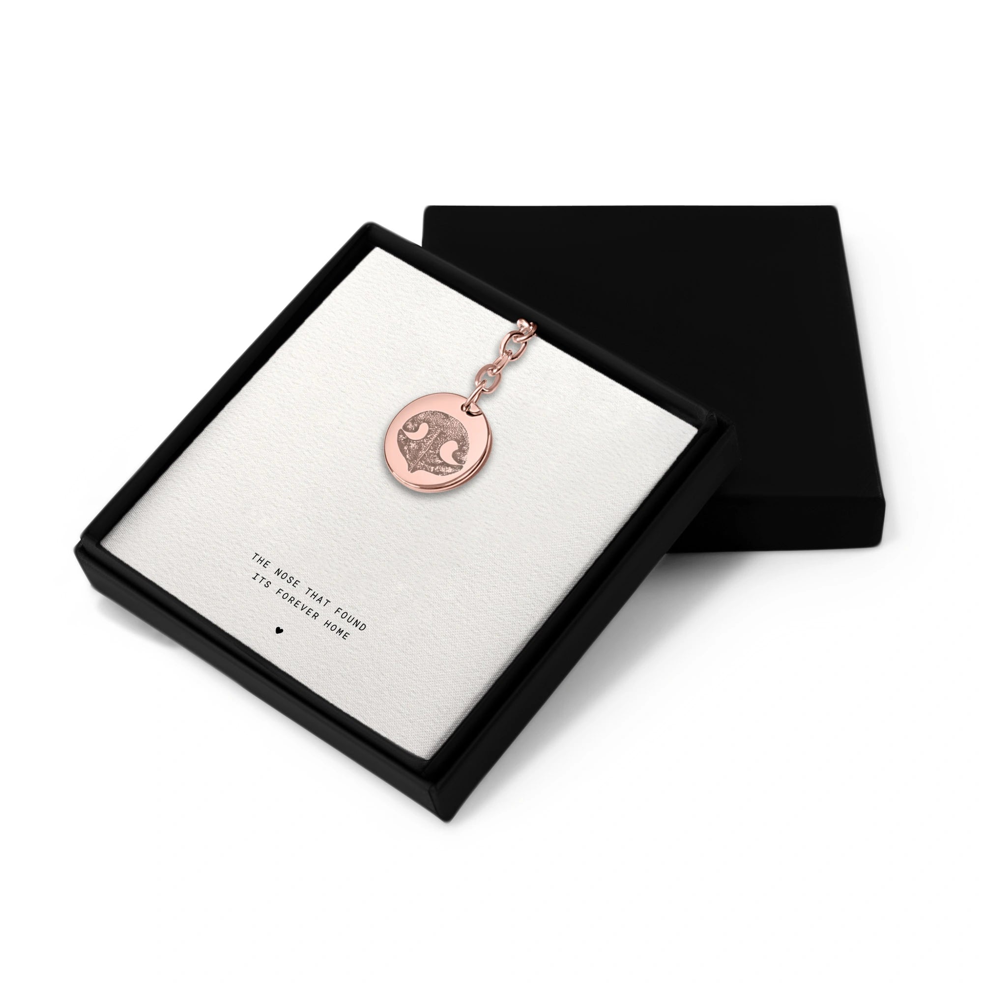 Rose gold keychain with a pendant featuring a dog nose print, set in a gift box with the phrase "The nose that found its forever home".