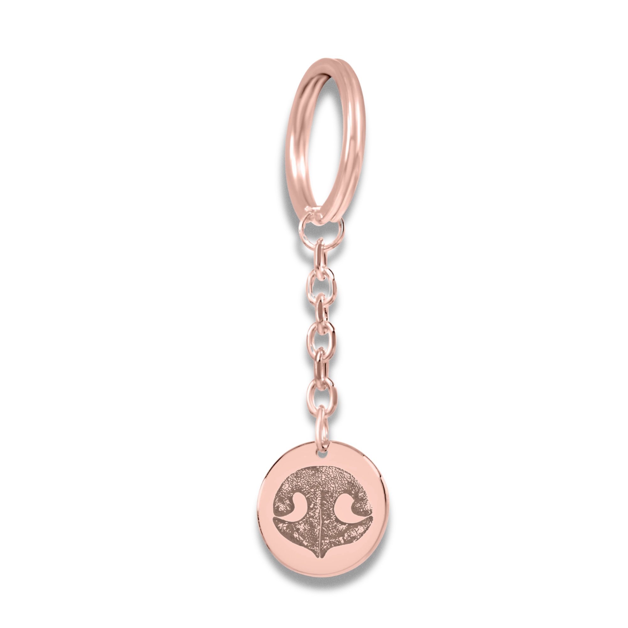 A rose gold keychain with a round pendant featuring a custom dog nose print.