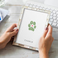 woman's hands holding dog paw print memorial