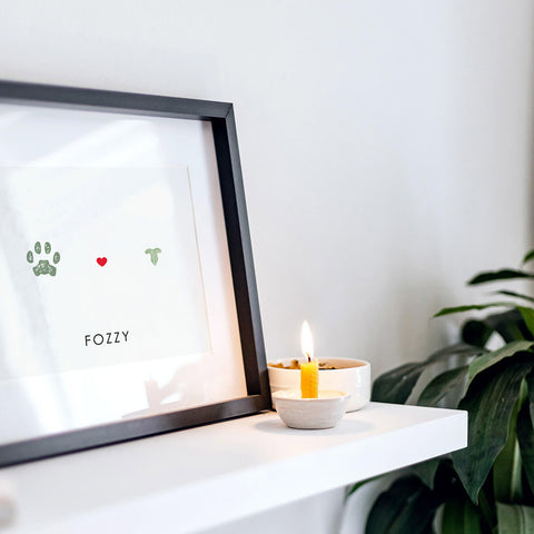 black framed cat nose and paw prints on shelf with candle