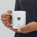 close up hands holding a white mug with dog nose print and dog name