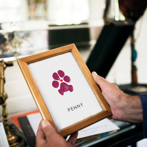 man holding framed dog paw print memento of pet