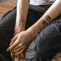 man's arms showing tattoos with two dog nose print tattoos