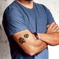 man with dog nose and dog paw arm tattoo standing with arms crossed