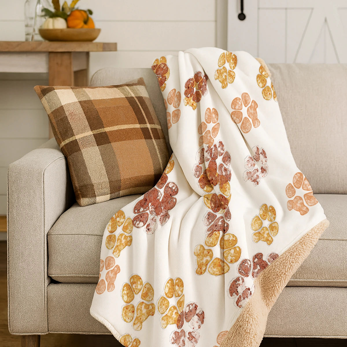 White blanket with scattered custom pet paw prints in shades of blue. The design feels playful.
