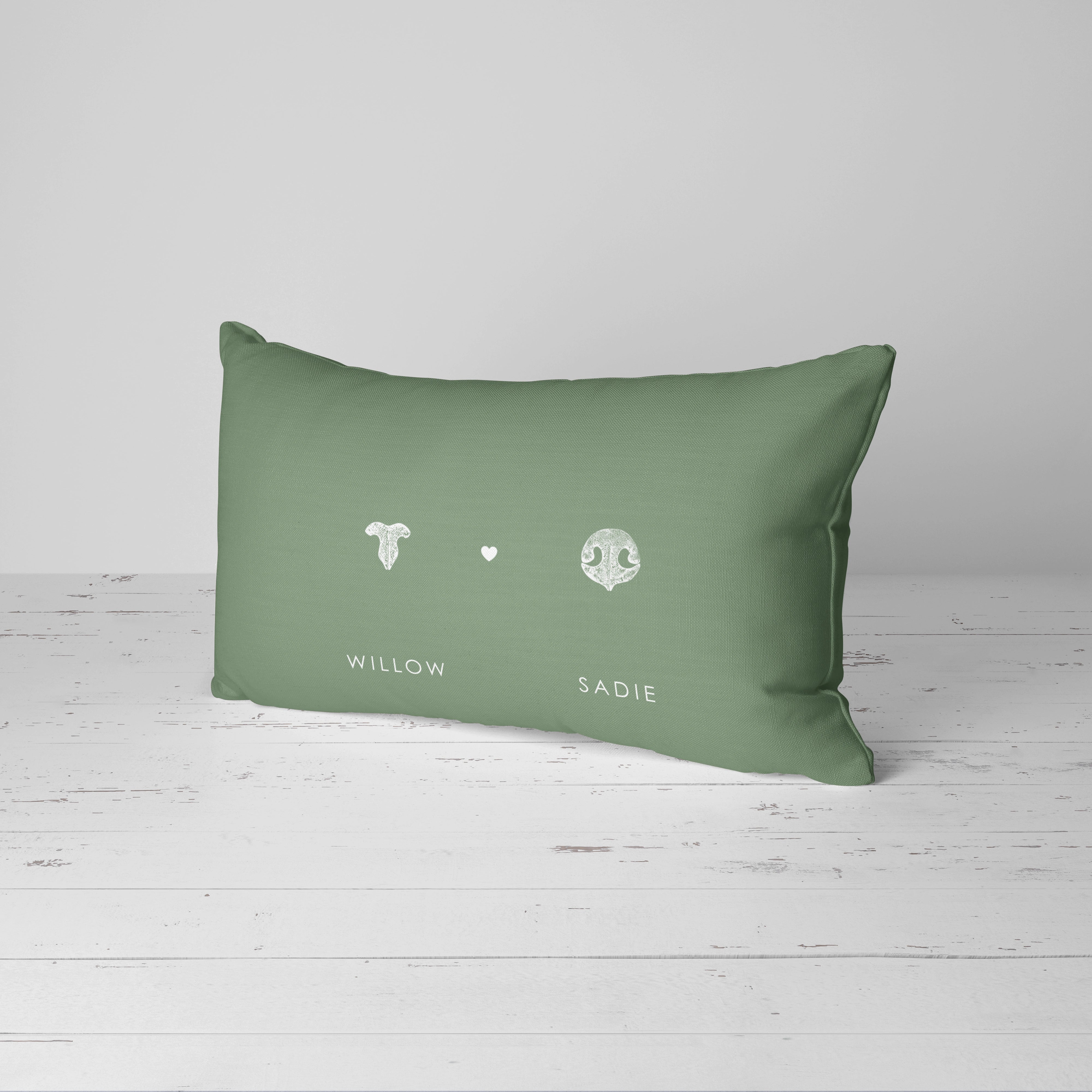 A green rectangular cushion displays two white pet nose prints and a heart, with 
