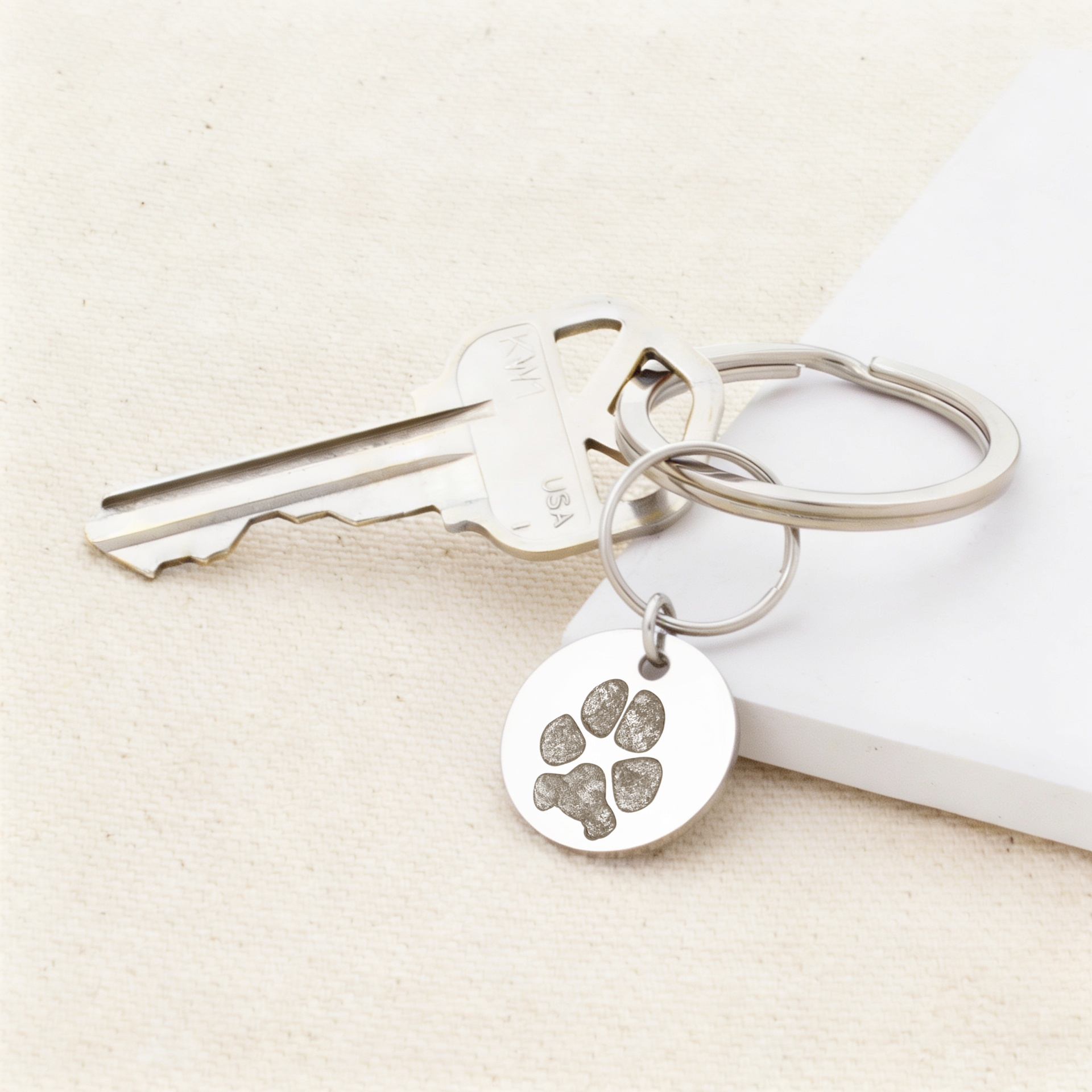 silver keychain with key on keyring and custom engraved dog paw print