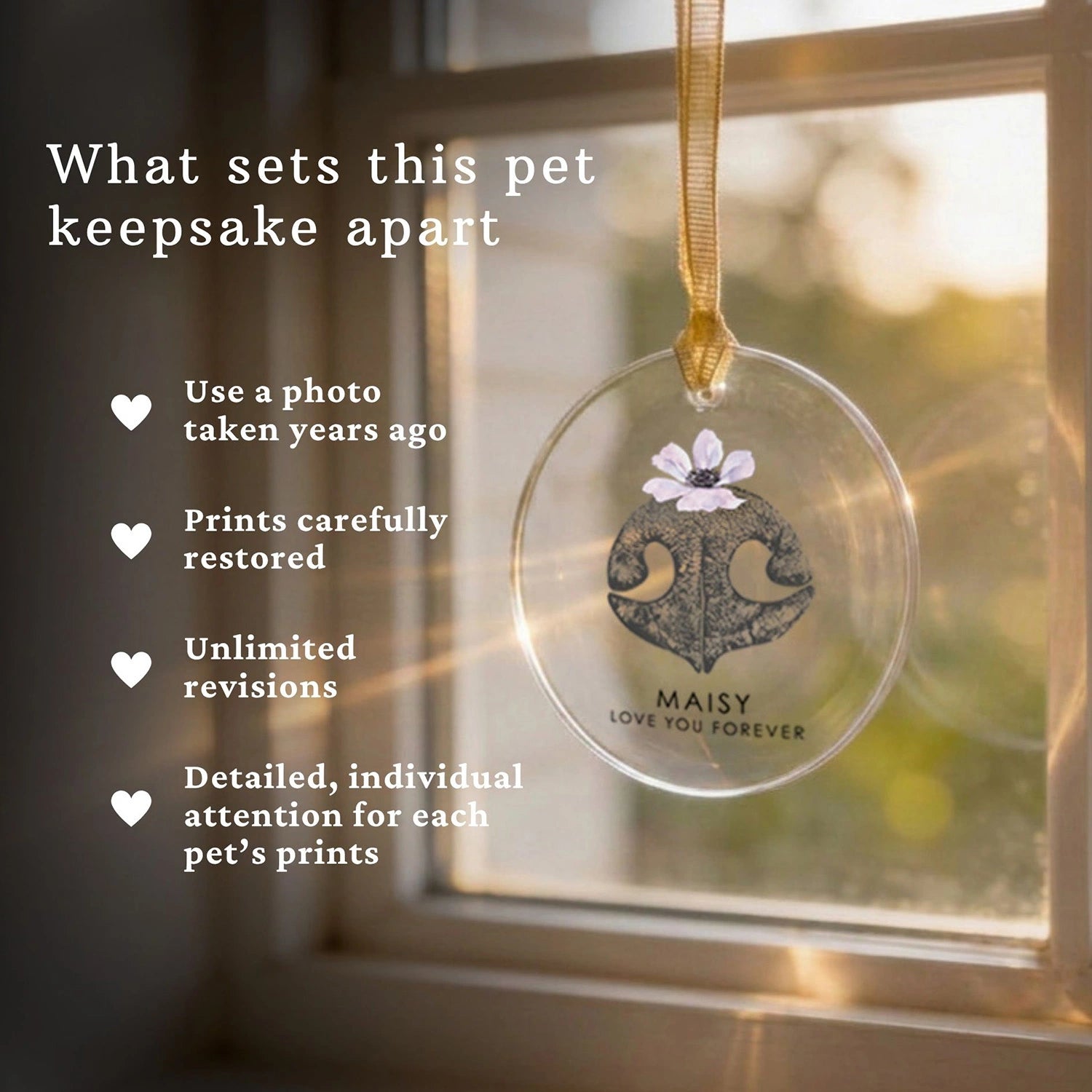 Pet nose print keepsake glass ornament with floral design and text, hanging by a window.