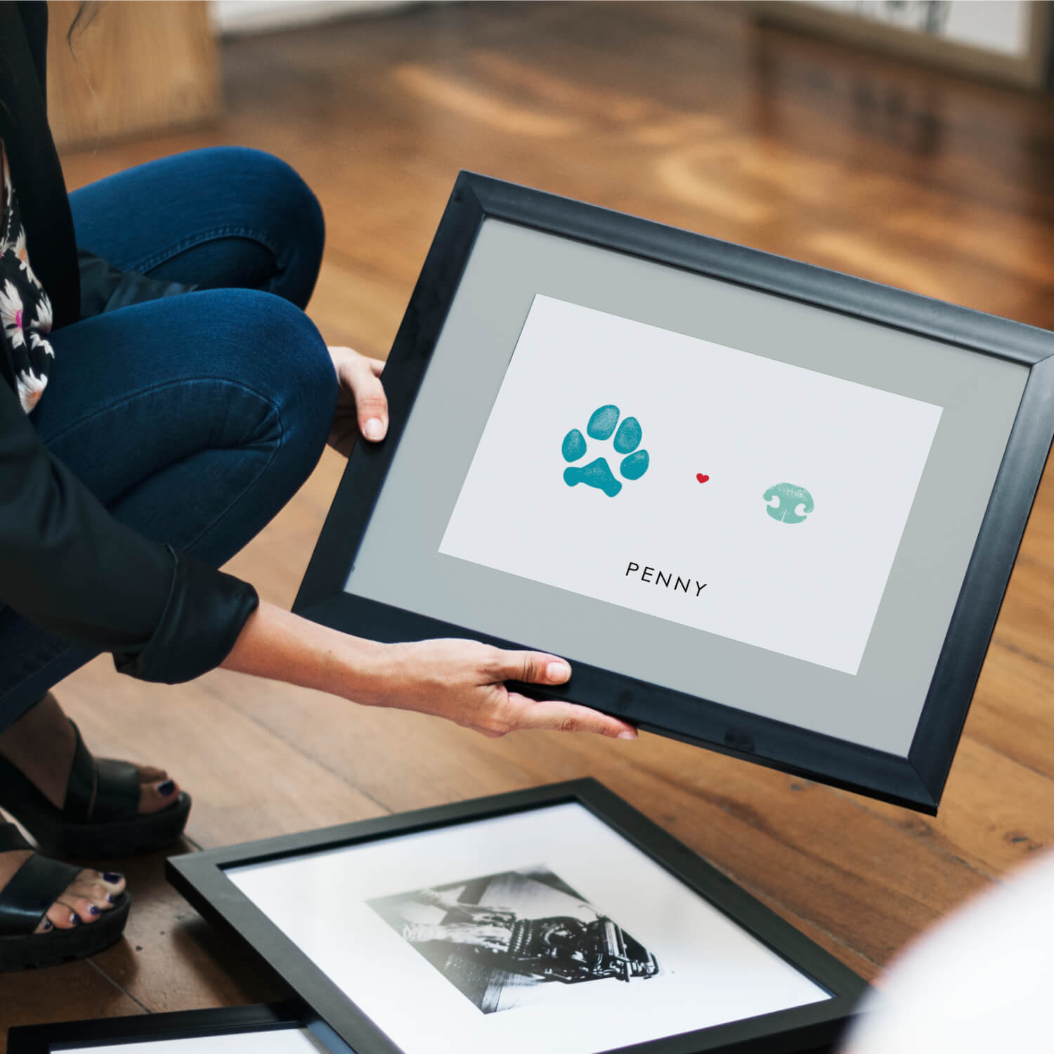 woman holding framed keepsake of pet prints for remembrance