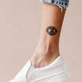 woman's ankle showing black dog nose print tattoo idea